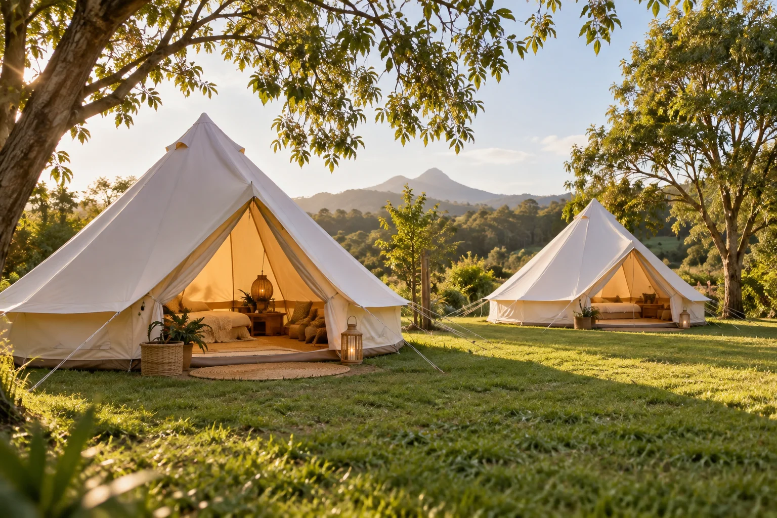 Spacious bell tents for glamping on open grass by a creek.